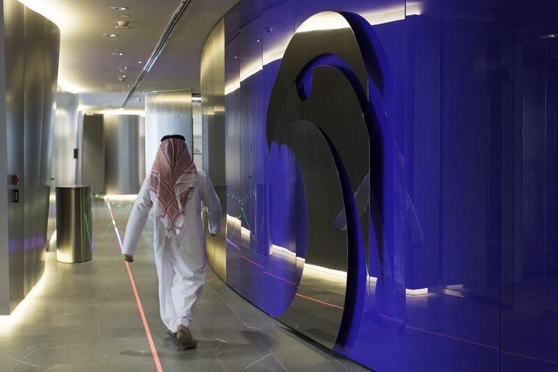 An employee passes the logo of the Abu Dhabi National Oil Company (ADNOC) displayed on a wall at the company's headquarters in Abu Dhabi, United Arab Emirates, on Thursday, Feb. 22, 2018. Adnoc is seeking to create world’s largest integrated refinery and petrochemical complex at Ruwais. Photographer: Christopher Pike/Bloomberg