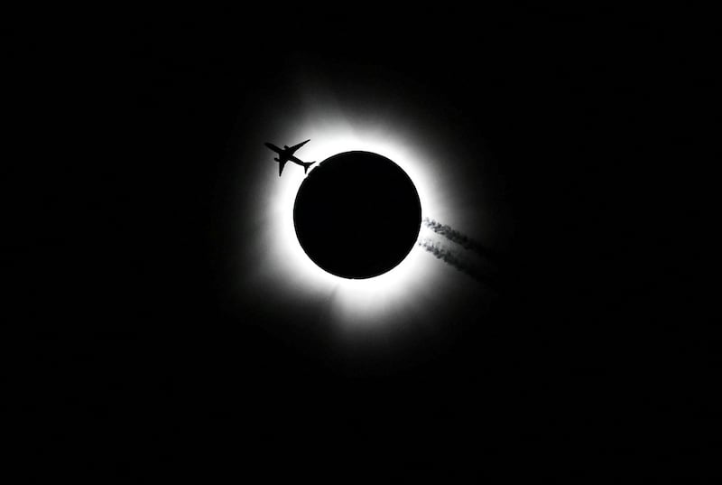 An aeroplane flies past the total solar eclipse as seen from the Hoosier Cosmic Celebration at Memorial Stadium in Bloomington, Indiana. Reuters