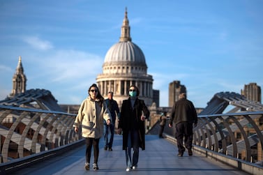 A woman crosses the millennium bridge in front of St Pauls Cathedral wearing a face mask for protection against the corona virus on March 16, 2020 in London, England. Getty Images