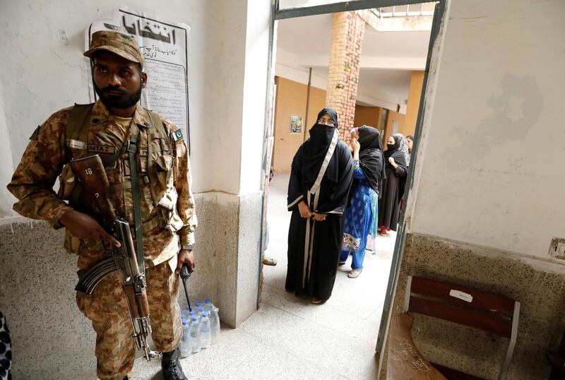 A soldier keeps watch as voters line up in Rawalpindi. Reuters