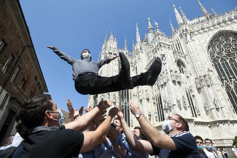 A newly ordained Catholic priest is launched into the air by friends and family outside Milan Cathedral. AFP