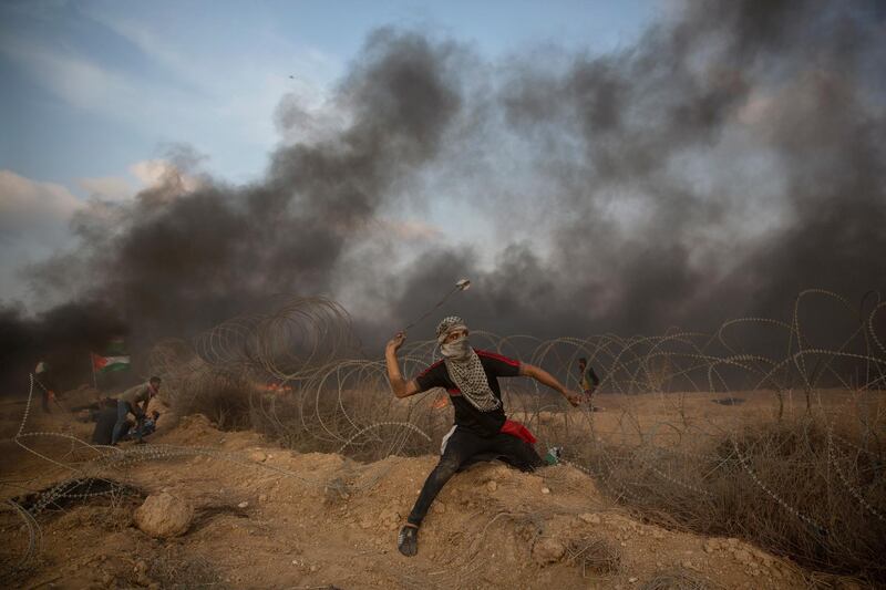 A Palestinian protester hurls stones towards Israeli troops at the Gaza Strip. AP