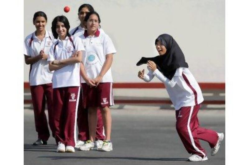 The high schooler Muafah Amran, right, plays cricket during a practice session at Cambridge International School.