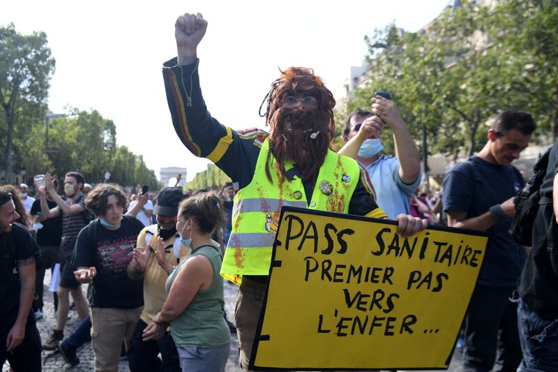A protester holds a placard reading ‘health pass, first step to hell’ during a demonstration in Paris, France.