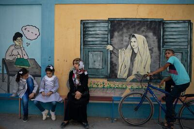 Two Palestinian girls, left, sit outside an UNRWA school before attending first day of class in Gaza City, Wednesday, Aug. 29, 2018. Hundreds of thousands of Palestinian children are starting their schoolyear in the Gaza Strip amid a major budget crunch for the United Nations agency that funds many schools. (AP Photo/Felipe Dana)