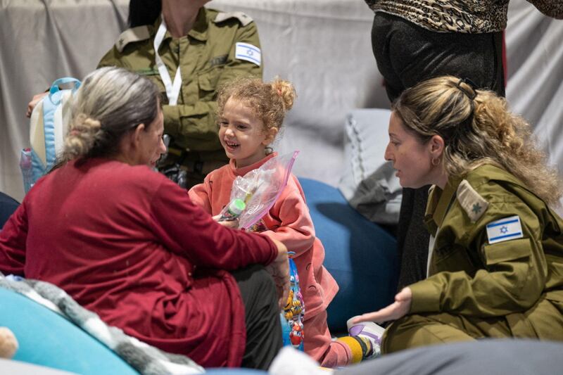 Yahel Shoham, three, and Sharon Avigdori, released Israeli hostages, interact shortly after their arrival in Israel. Reuters