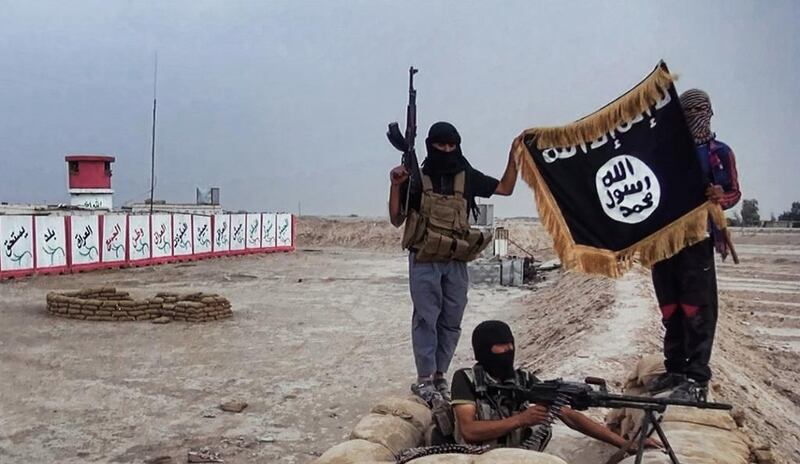 ISIL fighters pose with the group's trademark flag in the northern Iraqi province of Salahuddin. A local branch of the extremist group released the picture on June 11, 2014. Welayat Salahuddin/Handout/Agence France-Presse 