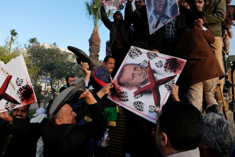 Supporters of Libyan National Army (LNA) commanded by Khalifa Haftar, hold a picture of Turkish President Tayyip Erdogan as they celebrate on top of a Turkish military armored vehicle, which LNA said they confiscated during Tripoli clashes, in Benghazi, Libya January 28, 2020. REUTERS/Esam Omran Al-Fetori