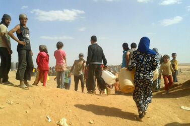 Syrian refugees gather for water at the Rukban refugee camp in Jordan’s northeast border with Syria. AP