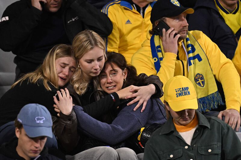 Swedish supporters in the stands are distraught when they hear of the shooting. AFP