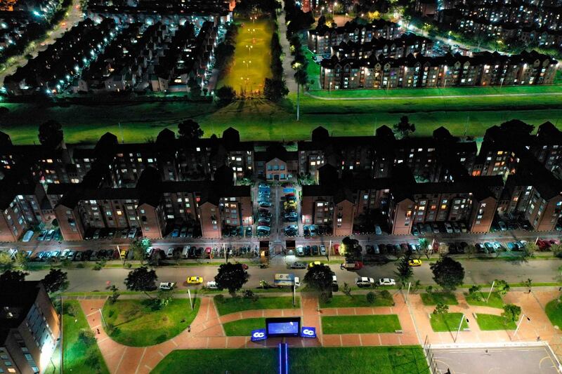 Aerial view as a film is projected on a giant screen at a park, so that quarantined people in their apartments watch a movie from home amid the coronavirus pandemic, in Bogota. Colombia extended mandatory preventive measures until at least May 11. AFP