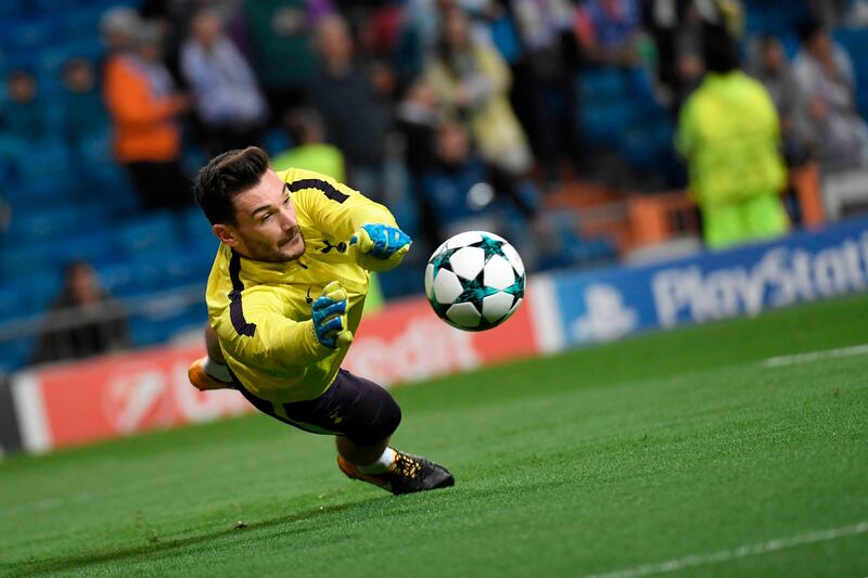 TOPSHOT - Tottenham Hotspur's French goalkeeper Hugo Lloris dives for the ball sduring a warm up before the UEFA Champions League group H football match Real Madrid CF vs Tottenham Hotspur FC at the Santiago Bernabeu stadium in Madrid on October 17, 2017. / AFP PHOTO / GABRIEL BOUYS