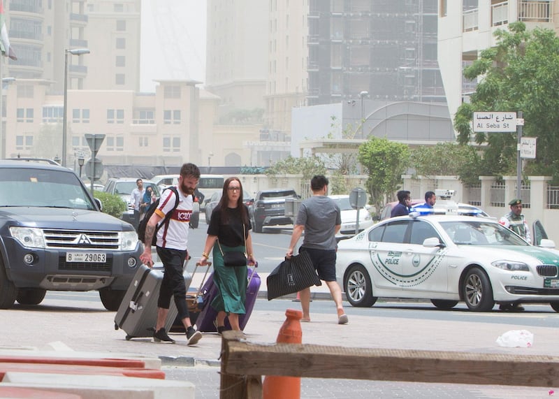 DUBAI, UNITED ARAB EMIRATES 13 MAY 2018 - Tourists in one of the hotels in Marina  with their luggage to find a cab  as police block the area around the burning building. Leslie Pableo for The National