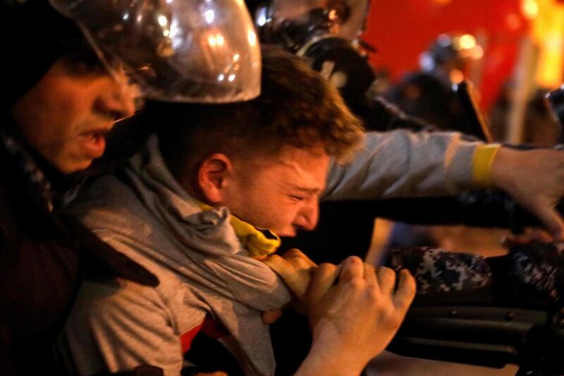 Riot police detain an anti-government protester. AFP
