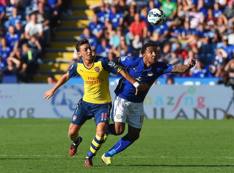 Mesut Ozil of Arsenal is challenged by Liam Moore of Leicester City during their Premier League match on Sunday. Michael Regan / Getty Images