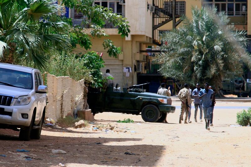 People walk past a military vehicle in Khartoum. AFP