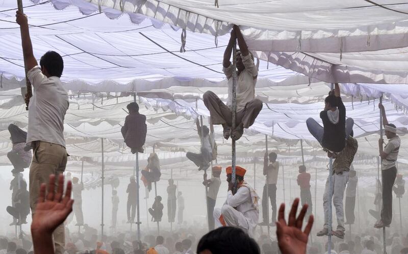 Supporters of Hindu nationalist Narendra Modi, the prime ministerial candidate for India’s main opposition Bharatiya Janata Party (BJP), climb over the poles of a temporary tent to get a glimpse of Modi during an election campaign rally at Mathura in the northern Indian state of Uttar Pradesh. K. K. Arora / Reuters