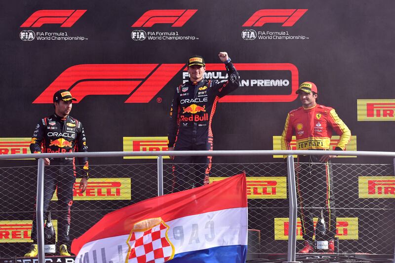 Red Bull's Max Verstappen celebrates on the podium after winning the Italian Grand Prix alongside second-placed Sergio Perez of Red Bull and third-placed Carlos Sainz Jr of Ferrari. Reuters