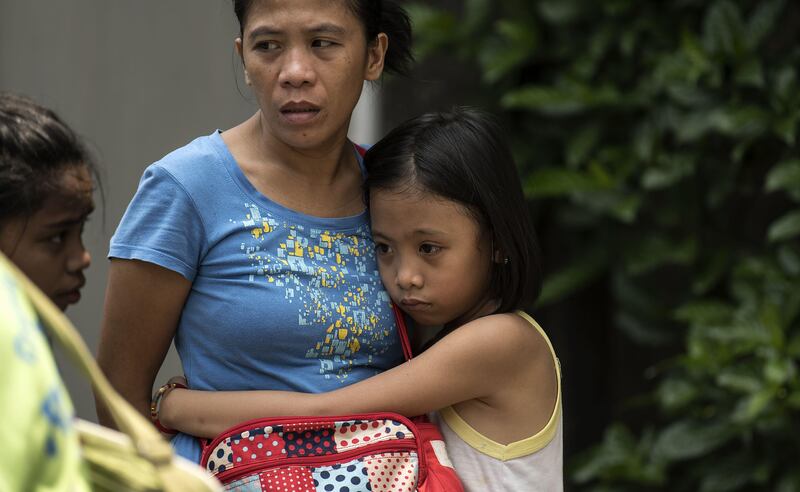 A girl hugs her mother after residents were evacuated from their homes.