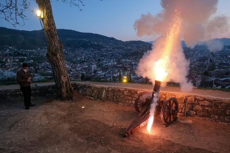 A man fires a vintage canon to signal the breaking of fast shortly after sunset in Sarajevo, Bosnia, on Friday, April 24, 2020. AP Photo