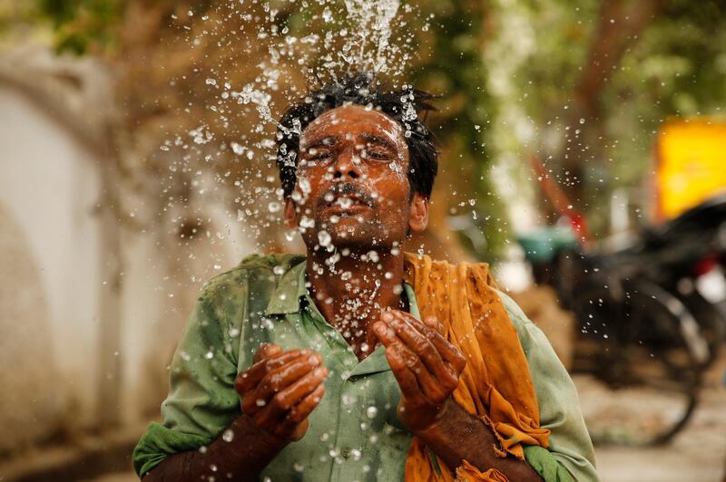A worker splashes water on his face to cool himself on a hot summer afternoon in Prayagraj, Uttar Pradesh, India, Thursday, June 13, 2019. Severe heat wave conditions are sweeping north and western parts of India with maximum temperature soaring to 48 degree Celsius (118 F) in some areas. (AP Photo/Rajesh Kumar Singh)