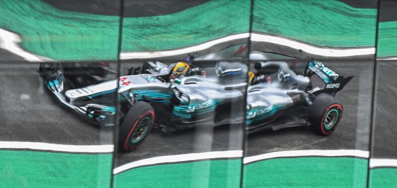 Mercedes driver Lewis Hamilton is reflected on windows as he powers his car during the Brazilian Formula One Grand Prix third practice session in Sao Paulo, Brazil.  Nelson Almeida / AFP Phot