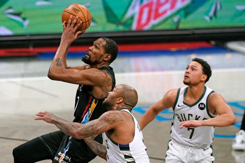Brooklyn Nets forward Kevin Durant (7) goes up to shoot with Milwaukee Bucks forward P.J. Tucker (17) and guard Bryn Forbes (7) looking on during the third quarter of Game 2 of an NBA basketball second-round playoff series, Monday, June 7, 2021, in New York. (AP Photo/Kathy Willens)