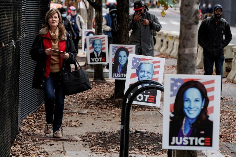 Pedestrians walk past campaign signs for Democratic presidential candidate former Vice President Joe Biden ahead of Election Day near the White House in Washington, D.C..  Reuters