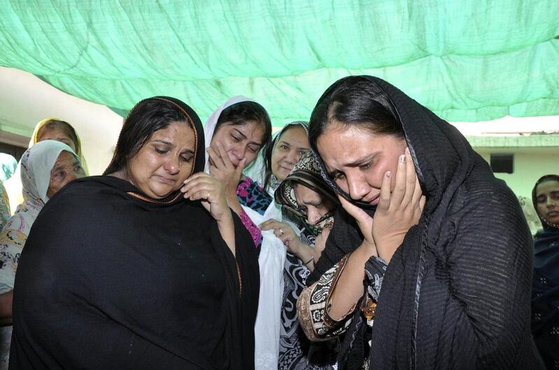 Relatives mourn over the body of Rashid Rehman, who was killed by unidentified gunmen at his residence in Multan. Reuters / May 8, 2014