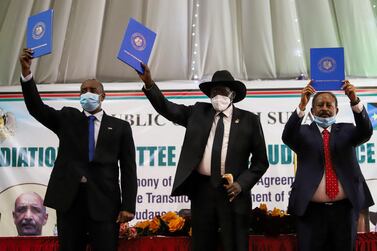 Sudan's Sovereign Council Chief General Abdel Fattah Al Burhan, South Sudan's President Salva Kiir, and Sudan's Prime Minister Abdalla Hamdok raise copies of a signed peace agreement with Sudan's five key rebel groups in Juba, South Sudan on August 31, 2020. Reuters