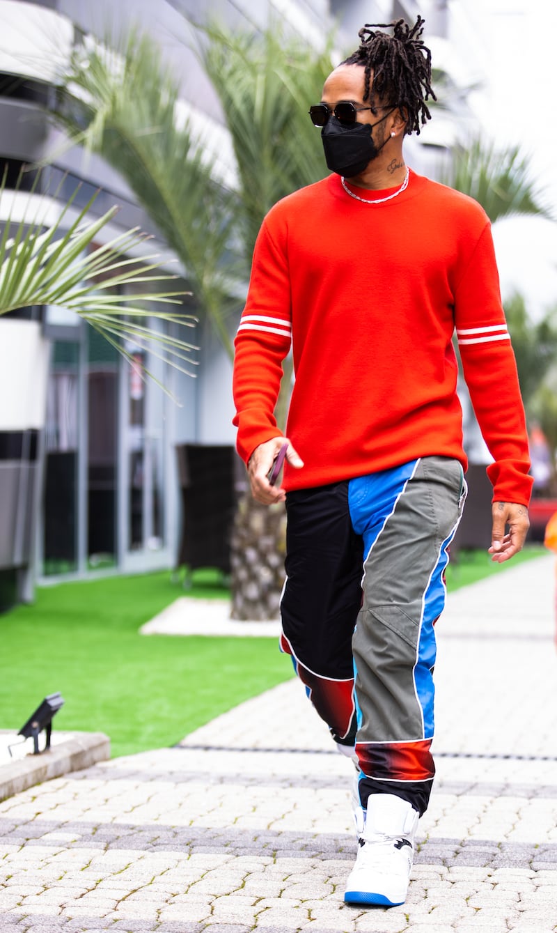 Lewis Hamilton, in a red Maison Margiela jumper and recycled Ahluwalia tracksuit bottoms, walks in the paddock ahead of the Russian Grand Prix at Sochi Autodrom on September 24, 2021. Getty Images