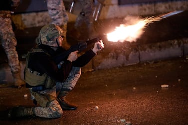 A Lebanese soldier fires tear gas against protesters during a protest against deteriorating living conditions and strict coronavirus lockdown measures, in Tripoli, Lebanon, Friday, Jan. 29, 2021. A tense calm prevailed in the northern Lebanese city of Tripoli on Friday after rioters set fire to several government buildings, capping days of violent clashes as anger over growing poverty made worse by the coronavirus lockdown boiled over. (AP Photo/Hussein Malla)