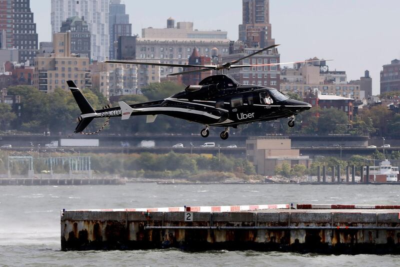 In this Wednesday, Oct. 2, 2019, photo an Uber helicopter lands at the Downtown Manhattan Heliport, in New York. The ride-hailing company expanded its helicopter service Thursday, Oct. 3, between lower Manhattan in New York City and John F. Kennedy International Airport, making it available to all Uber riders with iPhones instead of just those in the top tiers of its rewards program. (AP Photo/Richard Drew)