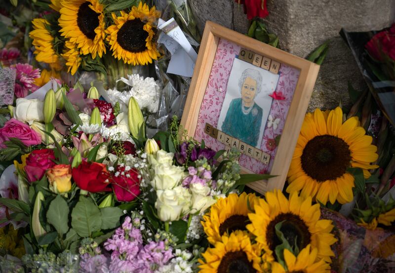 Sunflowers and a picture of Queen Elizabeth II lie outside Windsor Castle. Getty Images