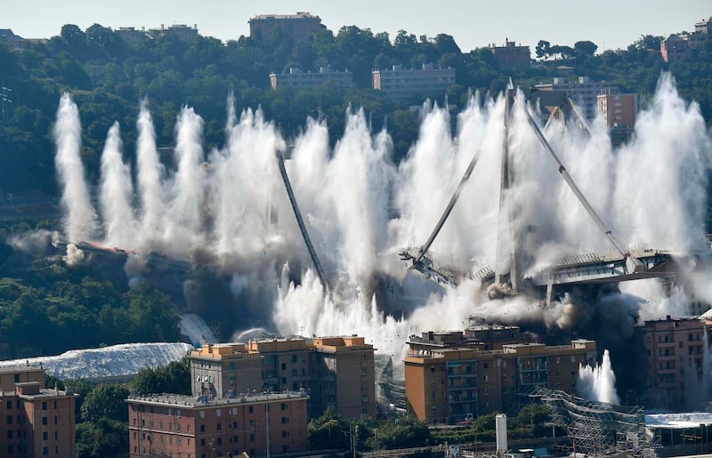 A cloud of dust rises as the remaining spans of the Morandi bridge are demolished in a planned expolosion, in Genoa, Italy, Friday, June 28, 2019. The spectacular planned explosion knocked down the remaining spans and supporting columns of the Italian bridge that collapsed last year, killing 43 people and some 3,500 people who live nearby had been evacuated as a precaution in the last hours; sirens sounded a final warning. (Luca Zennaro/ANSA via AP)