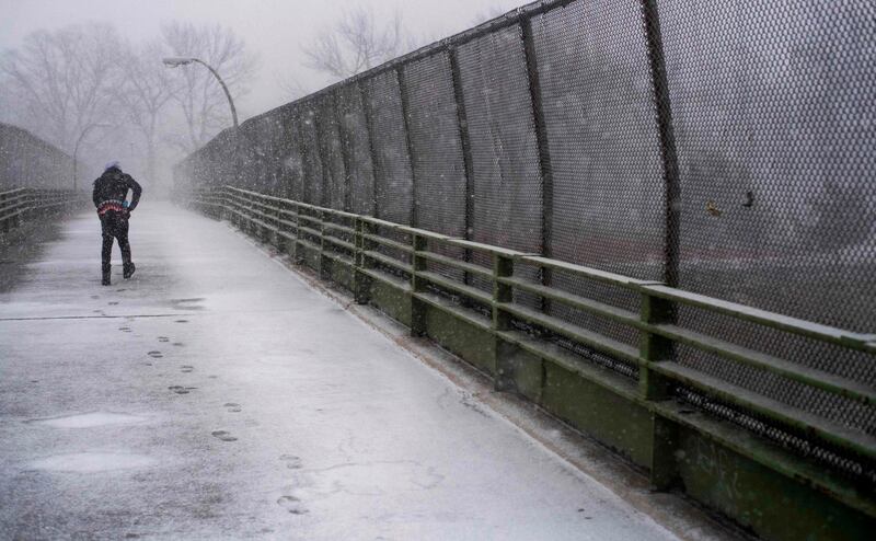 A man walks across a bridge as heavy snow falls in New York. AFP