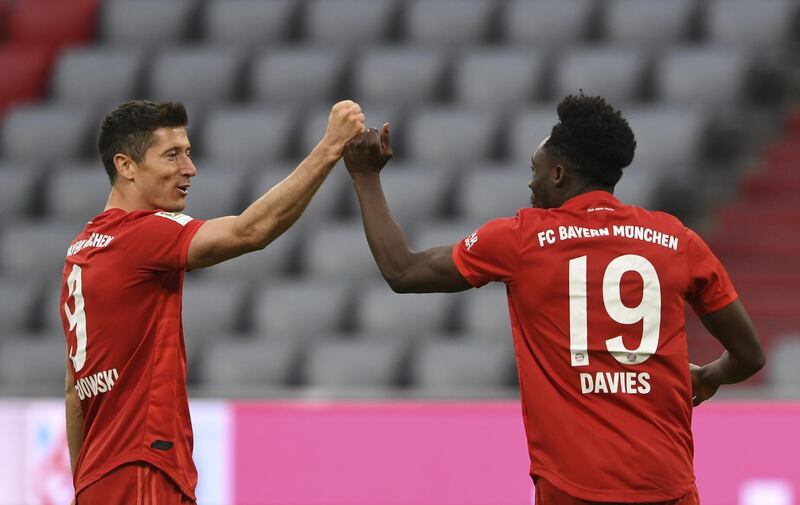 Bayern Munich's Robert Lewandowski, left, and team mate Alphonso Davies celebrate the fifth goal against Fortuna Duesseldorf on Saturday. AP