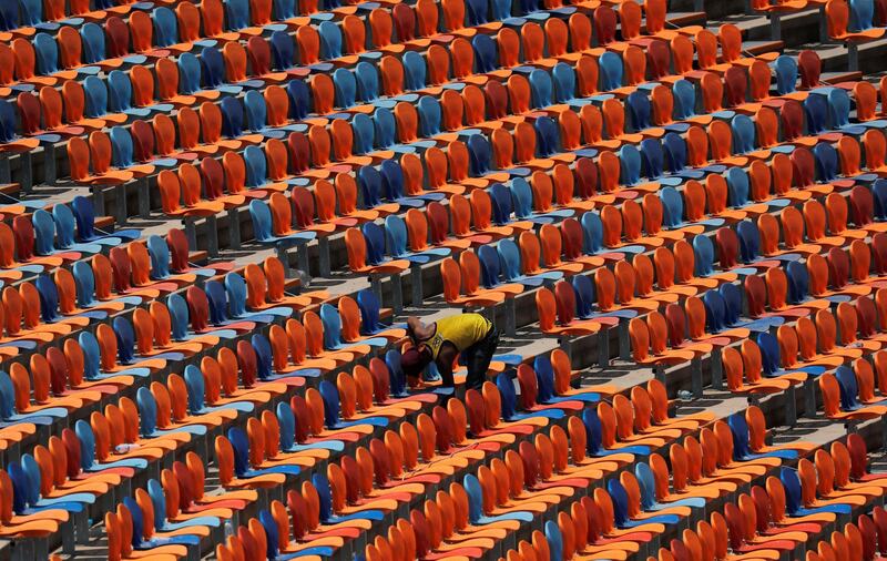 An employee fixes seats inside the Cairo International Stadium ahead of the Africa Cup of Nations opening soccer match between Egypt and Zimbabwe in Cairo, Egypt.  Reuters