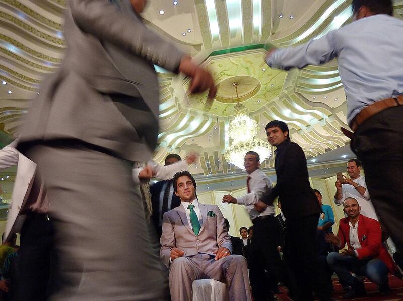 Young Afghan men dance around a groom during wedding celebrations at a wedding hall in Kabul. As Afghanistan's wedding season kicks into high gear, lawmakers are pushing for austerity, bent on taming out-of-control guest lists. Shah Marai/AFP Photo

