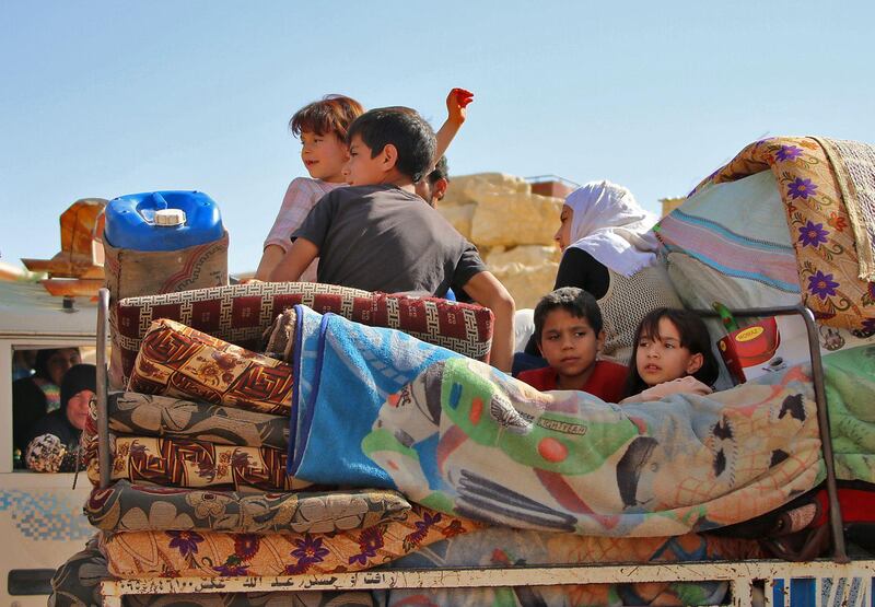 Syrian refugees children ride on a vehicle getting ready to cross into Syria from the eastern Lebanese border town of Arsal, Lebanon, on June 28, 2018. Stringer / AFP