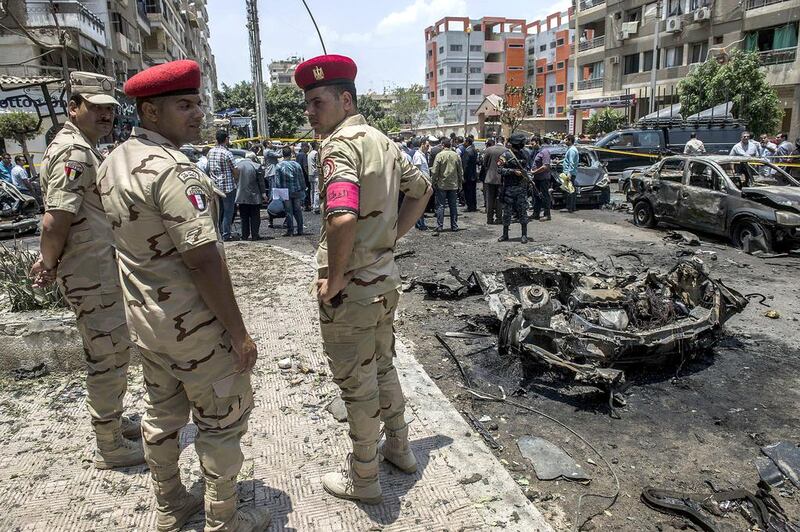 Members of the Egyptian security forces stand guard as people gather at the site of a bomb that killed the Egyptian state prosecutor, Hisham Barakat, in the capital Cairo on June 29, 2015. Khaled Desouki/AFP Photo