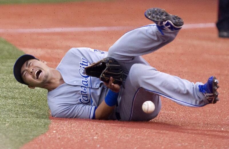 Kansas City Royals right fielder Nori Aoki slides awkwardly to the ground while dropping a foul ball by Toronto Blue’ Jays Edwin Encarnacion during the third inning of a baseball game in Toronto. Fred Thornhill / Canadian Press