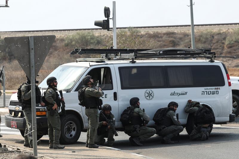 Israeli border police take cover by a vehicle, near Sderot. Reuters