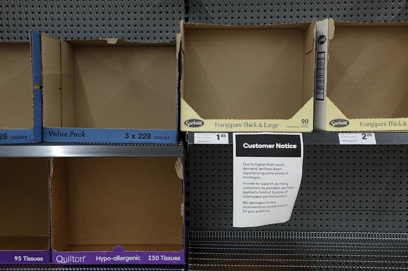 A notice indicating a shortage of supplies is displayed on empty tissue paper shelves at a supermarket in Sydney, Australia. Bloomberg