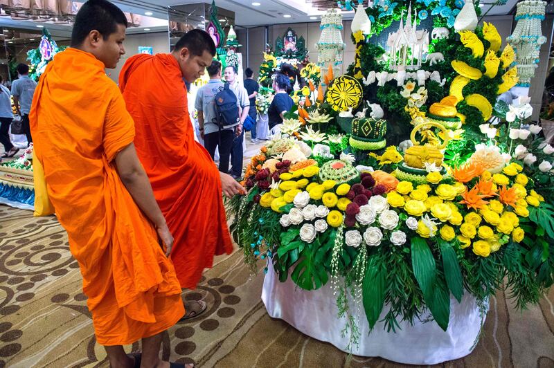 Two Buddhist monks look at an elaborate display of carved fruits and vegetables during a fruit and vegetable carving competition in Bangkok. Robert Schmidt / AFP