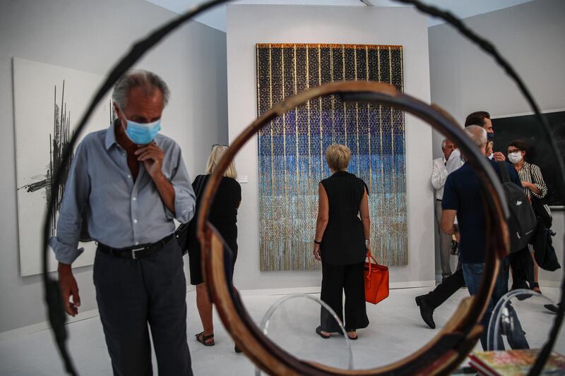 A woman looks at painting entitled 'Perlé Or, 2020' by French artist Beatrice Casadesus inside Galerie Dutko during the Art Paris 2020 art fair held at the Grand Palais, in Paris, France. EPA