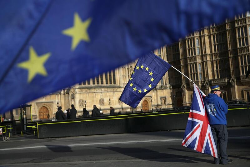 A pro-European Union,(EU), anti-Brexit demonstrator holds the EU and UK flags outside the Houses of Parliament, in central London on January 22, 2018. / AFP PHOTO / Daniel LEAL-OLIVAS