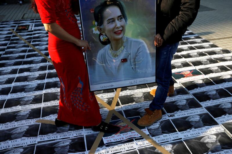 Myanmar protesters residing in Japan stand on pictures of Myanmar's army chief Min Aung Hlaing as they rally against the country's military after it seized power from a democratically elected civilian government and arrested its leader Aung San Suu Kyi, shown in the portrait, at United Nations University in Tokyo, Japan February 1, 2021. REUTERS/Issei Kato     TPX IMAGES OF THE DAY