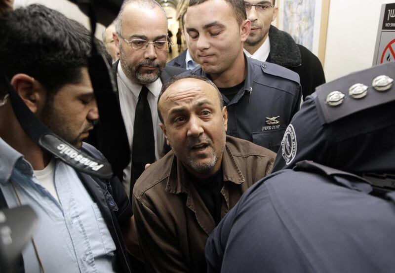 Jailed Fatah leader Marwan Barghouti, centre, is accompanied by Israeli prison guards at the Jerusalem magistrate's court on January 25, 2012. Ammar Awad / Reuters