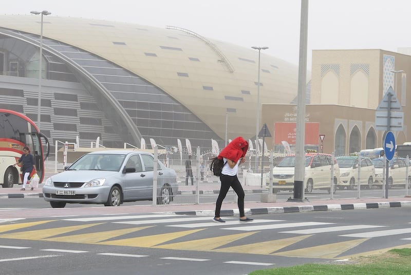Dubai, United Arab Emirates - March 20, 2017.  Pedestrian protects herself against the windy situation, at the Ibn Batuta area.  ( Jeffrey E Biteng / The National ) *** Local Caption ***  JB200317-Weather04.jpg